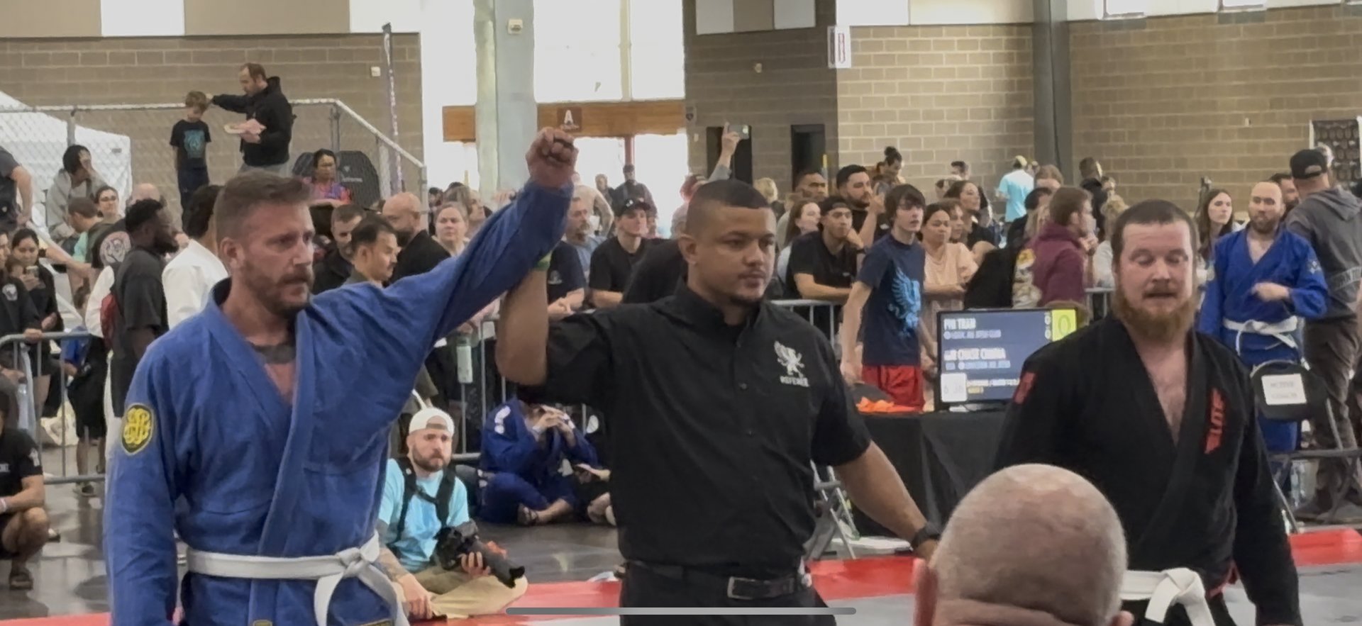 Referee raising the hand of a HempWeave athlete in victory